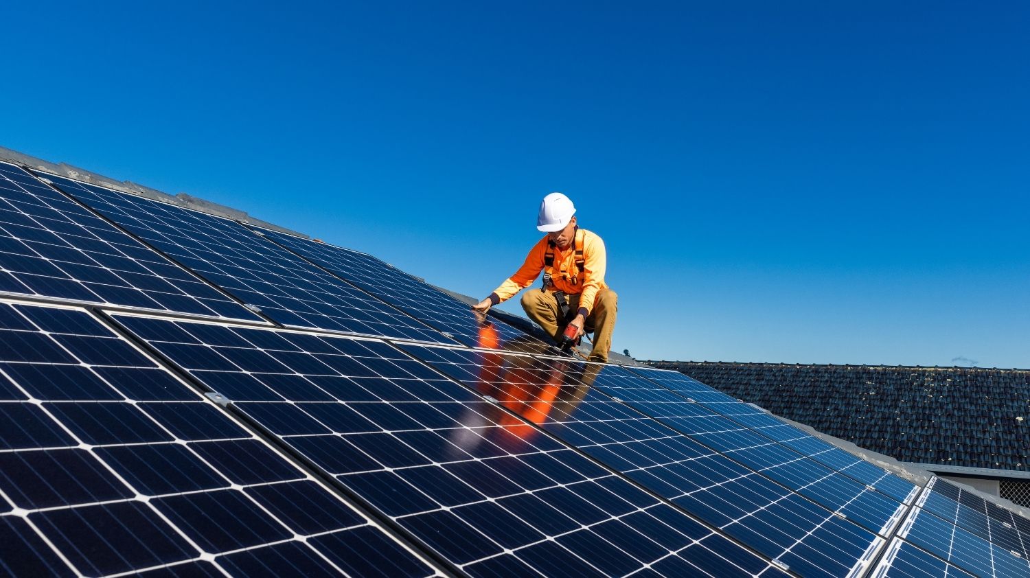 man on roof installing solar panels